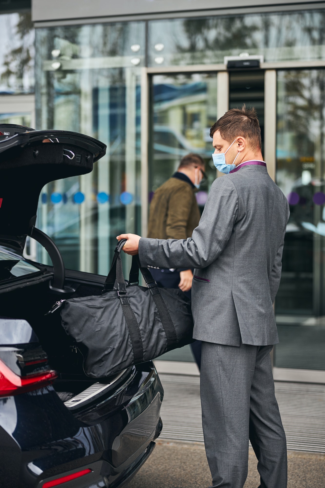 Driver helping his passenger with his luggage